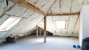 Isolation des combles d'une maison avec de la mousse de polyuréthane projetée sur les murs et le plafond.